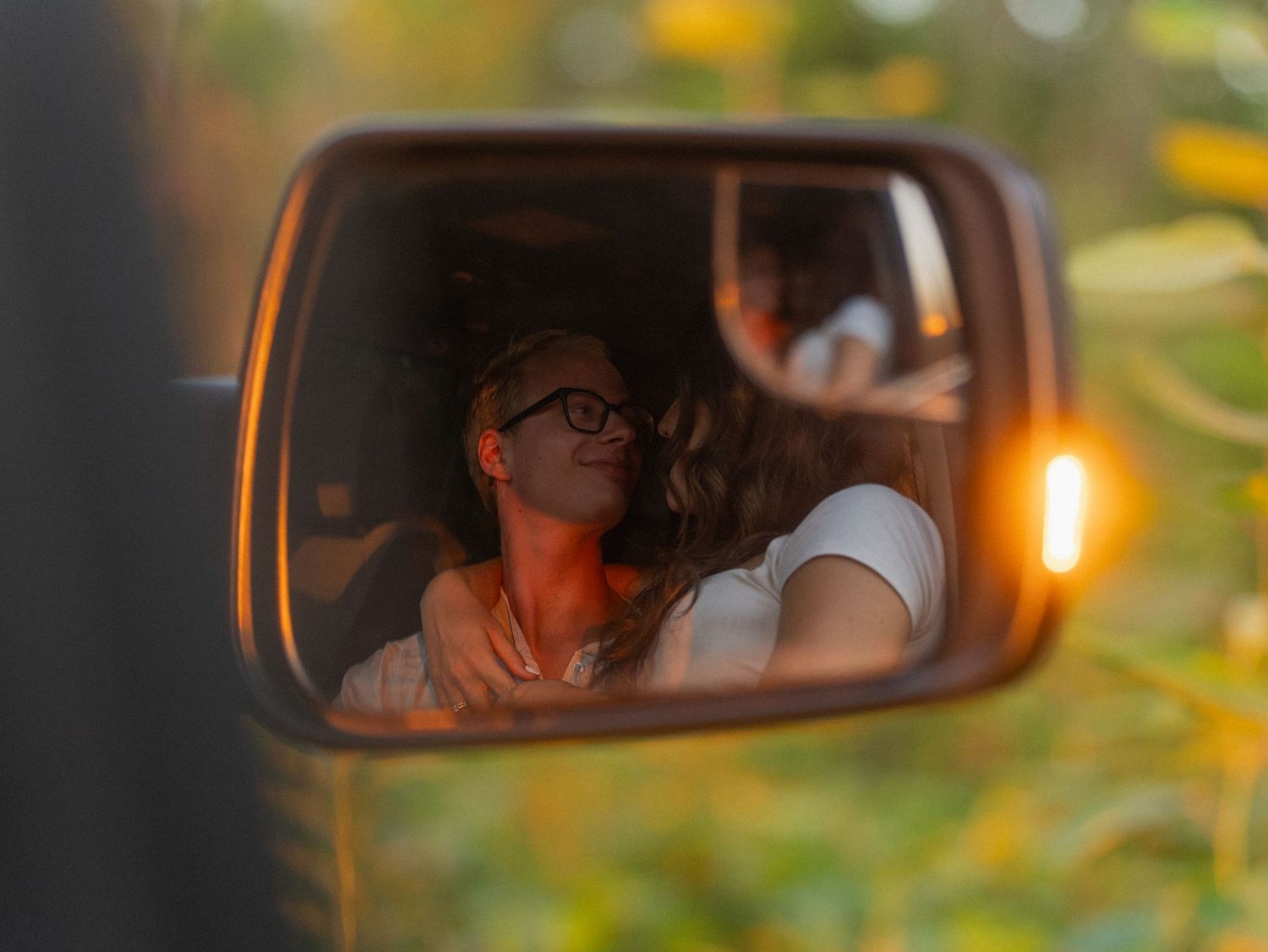 Candid Taipei couple photography reflected in a car mirror during golden hour