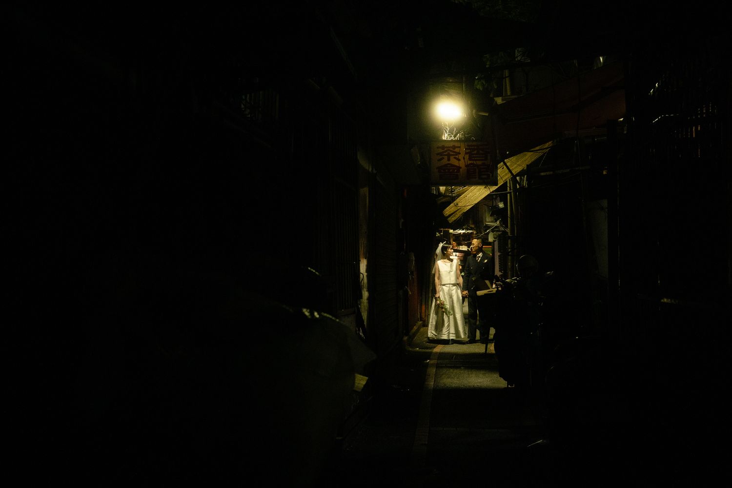 Cinematic Taipei pre-wedding portrait of a couple framed by glowing food stall lights at Huaxi Street Night Market
