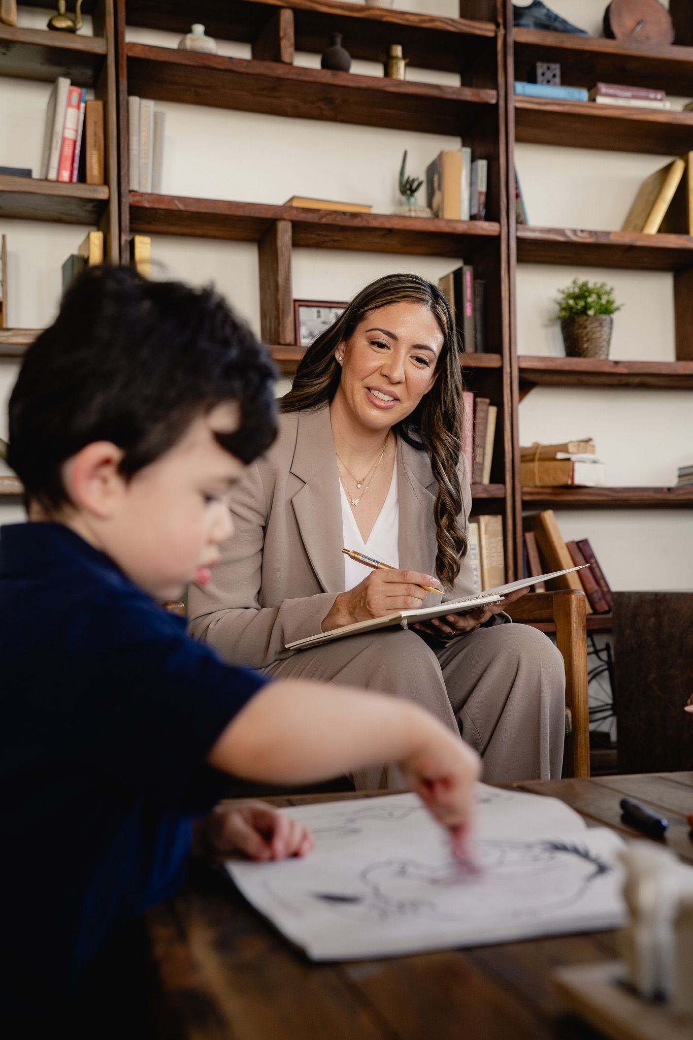 Lifestyle branding photo of a consultant working with a child in a warm studio setting