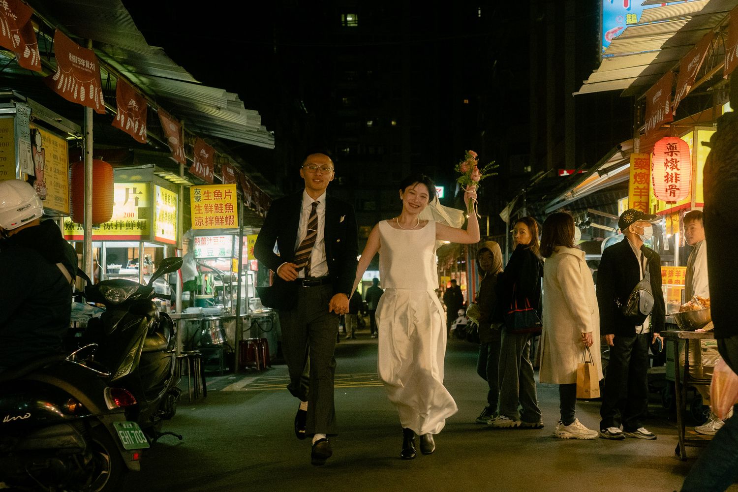Cinematic pre-wedding photoshoot in Taipei night market with couple running toward the camera