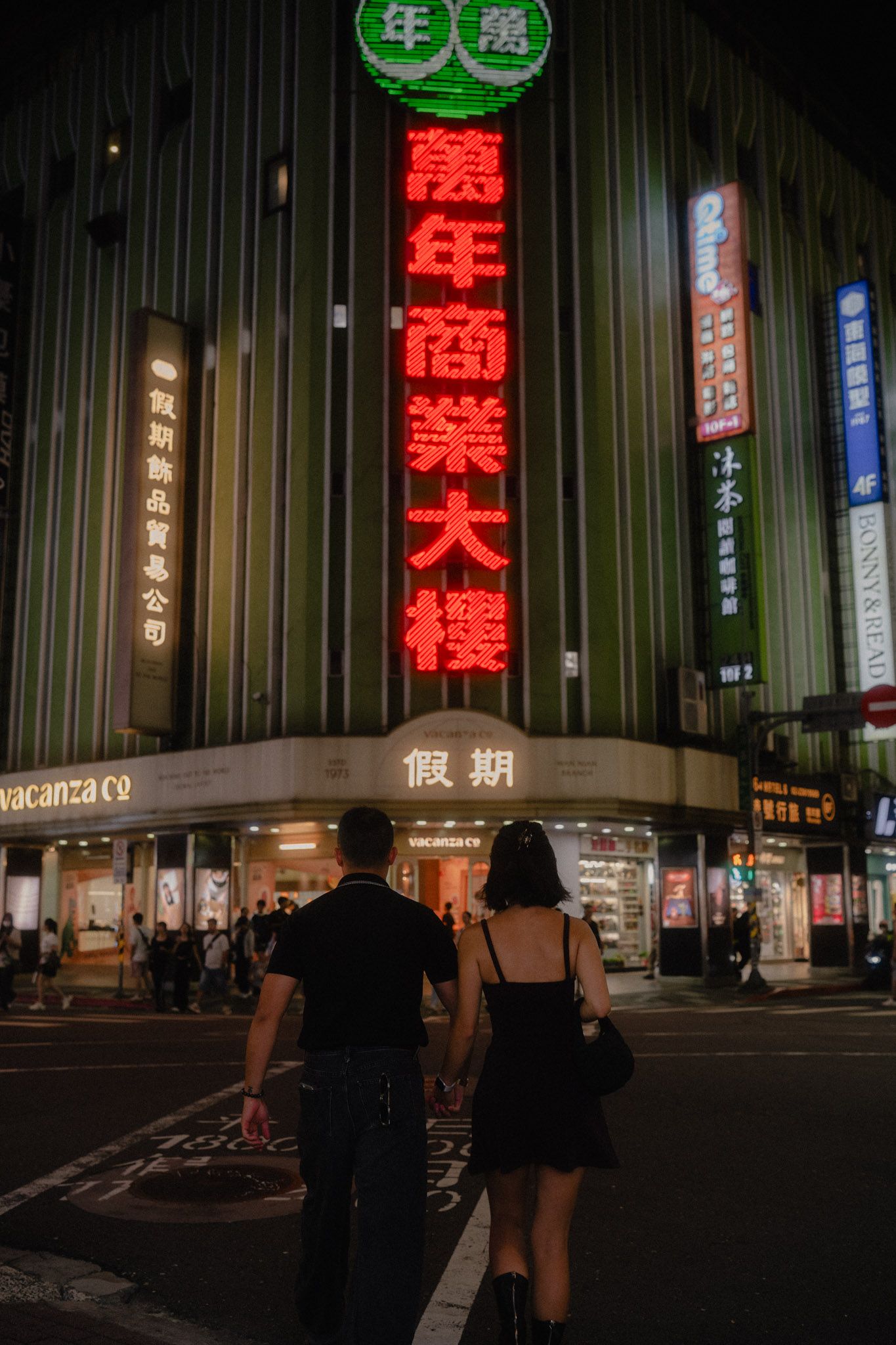 Couple walking hand in hand toward Wan Nian Building during their Ximending couple photoshoot in Taipei