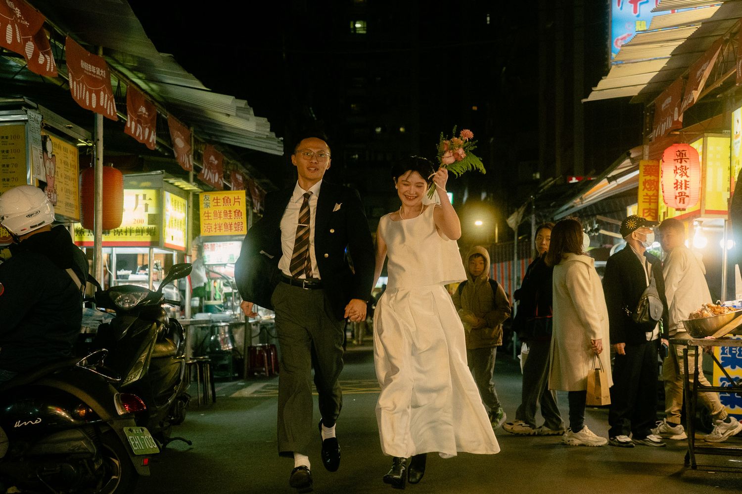 Sunny and Leo running hand in hand through Huaxi Street Night Market during their cinematic Taipei pre-wedding photoshoot