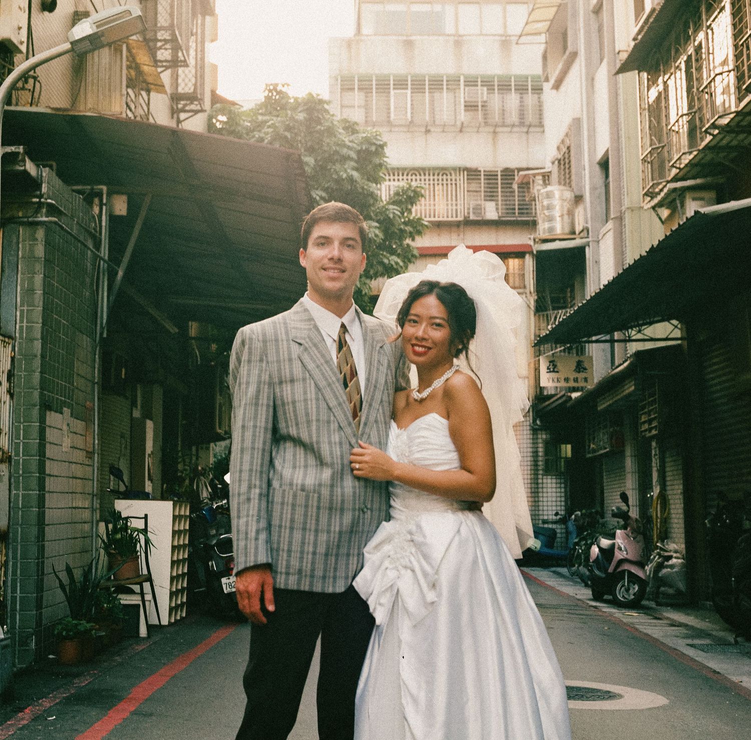 Cinematic Taipei pre-wedding photography of a bride and groom standing on an old city street shot in film
