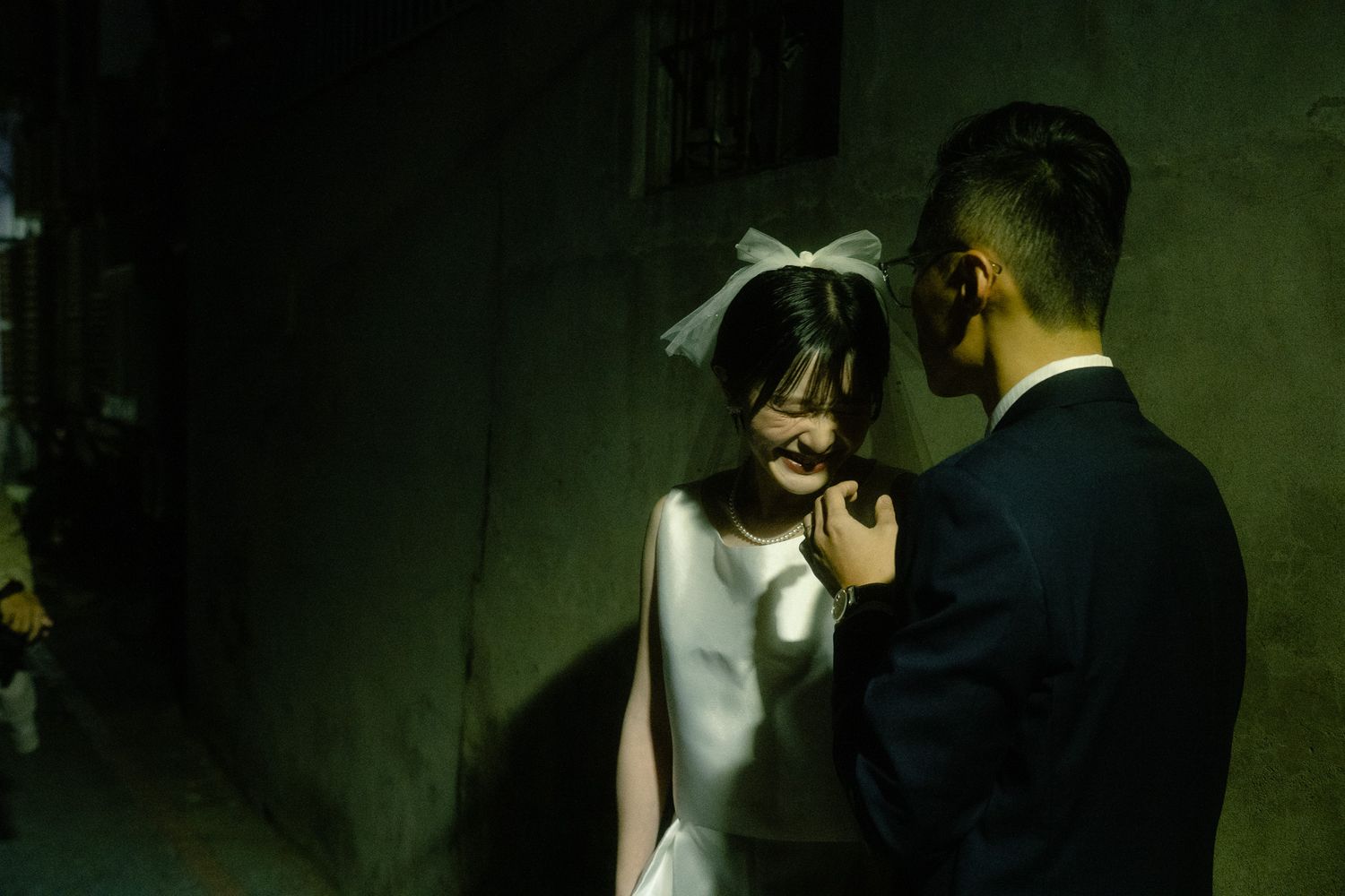 Bride laughing with her groom in dramatic green light during a cinematic Taipei night photography session