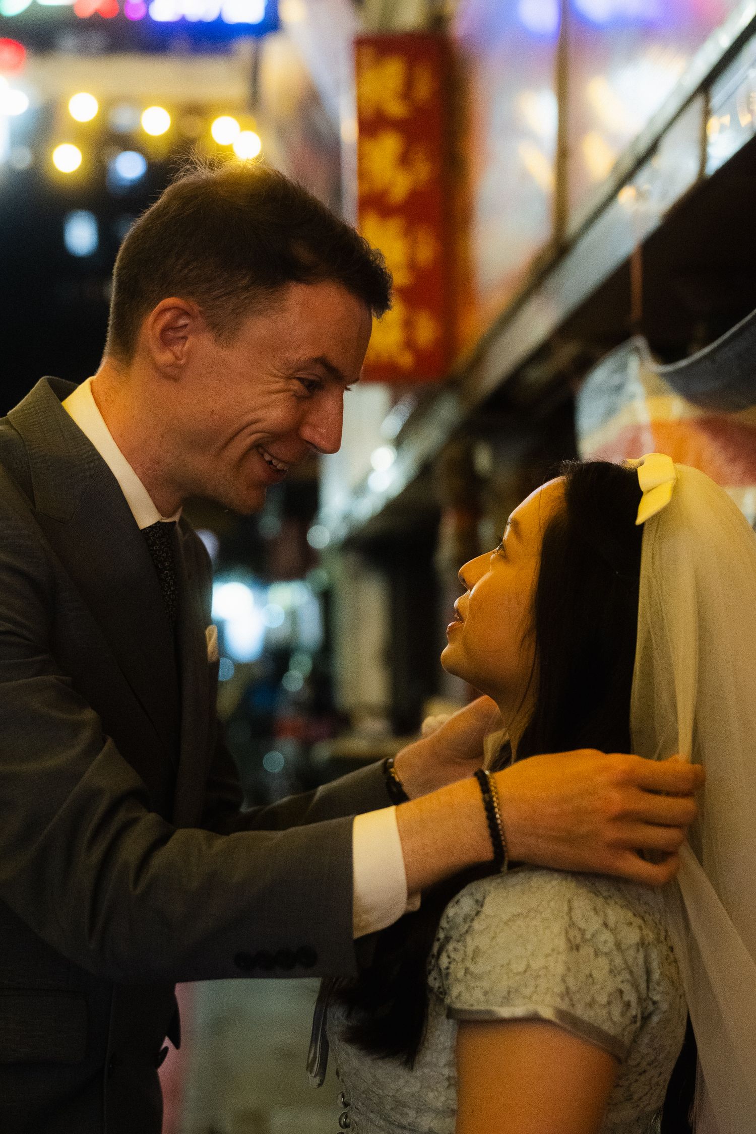 Candid portrait of a bride and groom smiling at each other during their nighttime pre-wedding photoshoot in Taipei.
