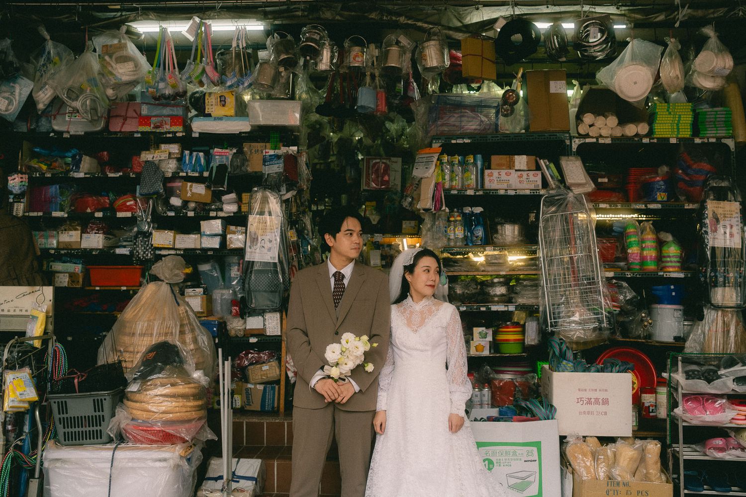 Bride and groom posing outside a traditional household goods shop during a Dihua Street pre-wedding session in Taipei