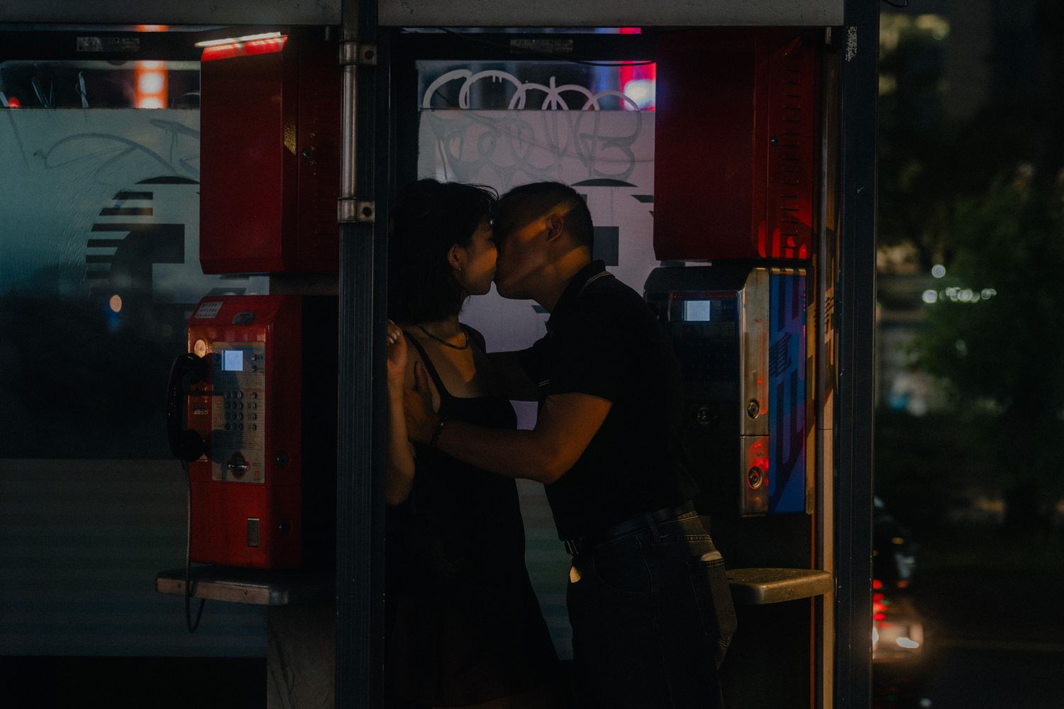 Taipei couple photoshoot at night featuring a couple kissing inside a vintage street phone booth.