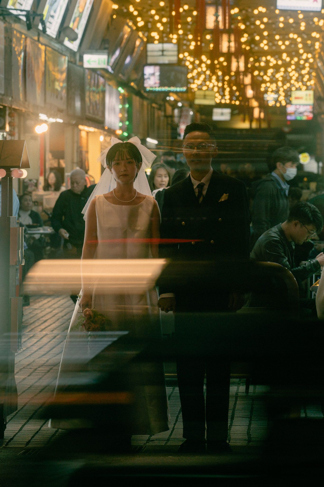 Sunny and Leo running hand in hand through the streets of Taipei during their night market pre-wedding photoshoot
