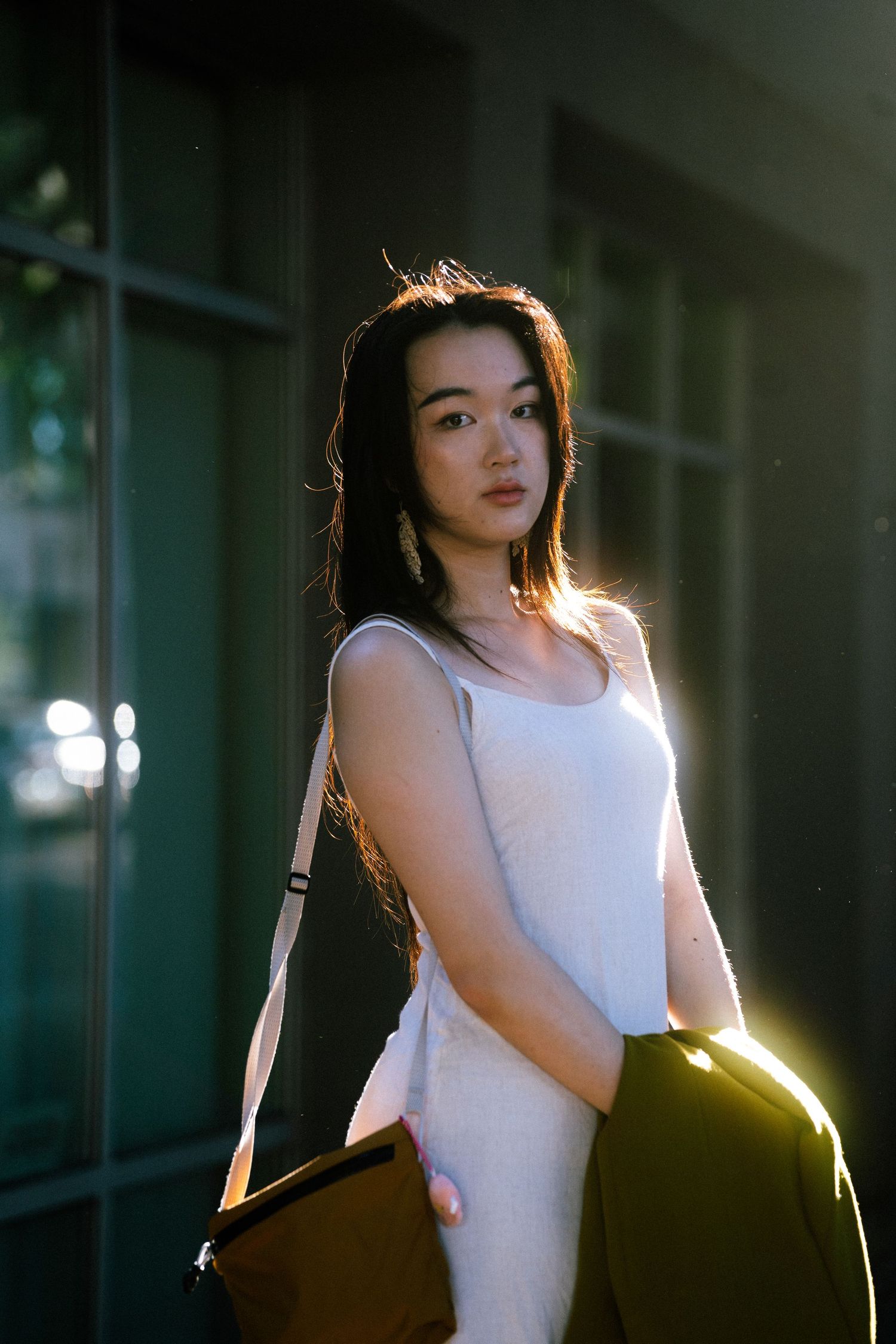 Cinematic Taipei portrait photography of a woman standing in dramatic window light