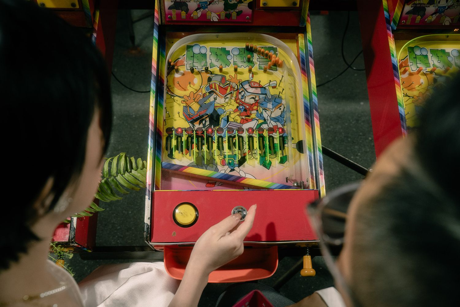 Bride and groom playing a vintage pinball game during their cinematic Huaxi Street Night Market pre-wedding photoshoot in Taipei