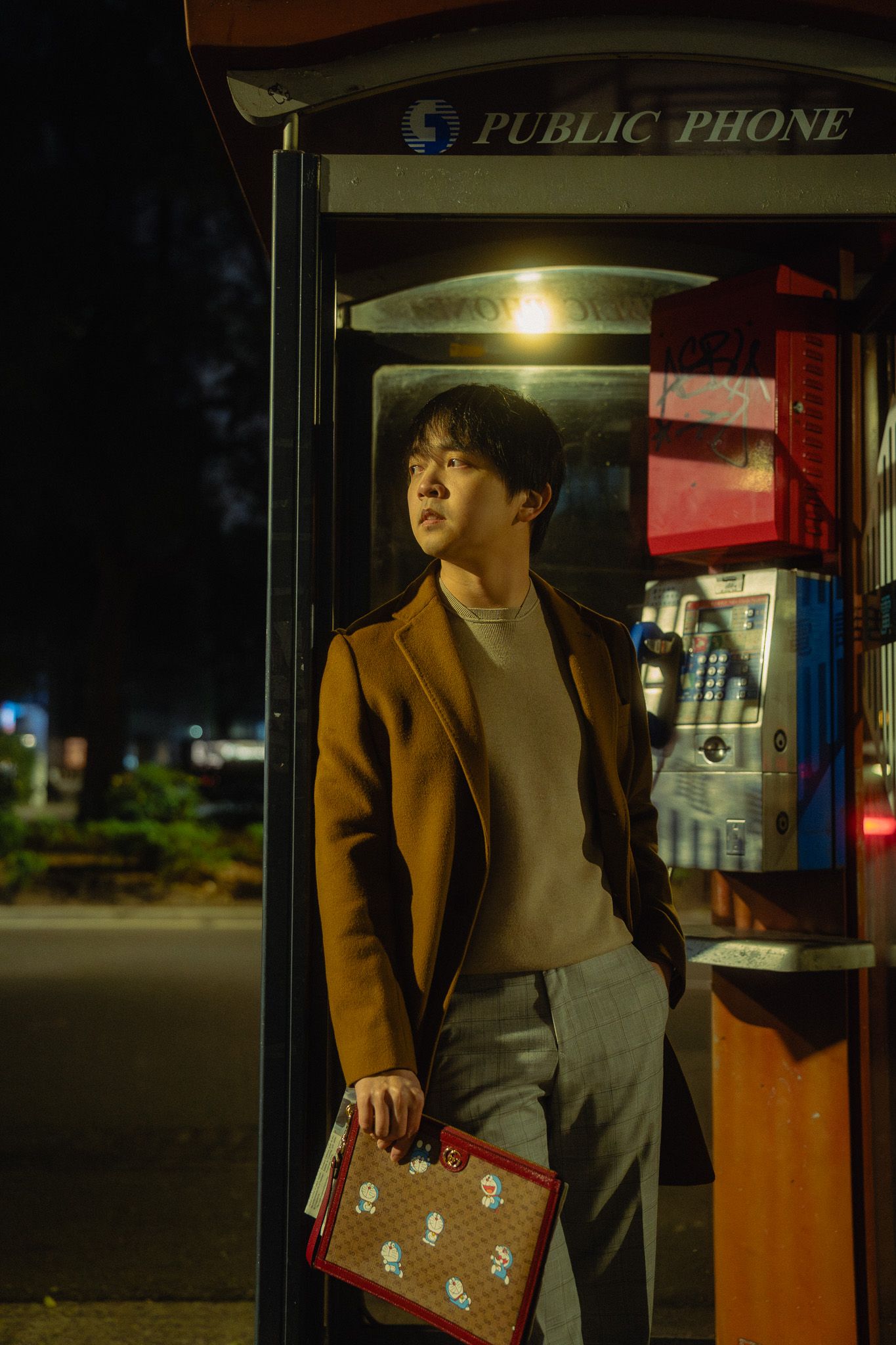 Cinematic Taipei lifestyle portrait of a content creator by a phone booth