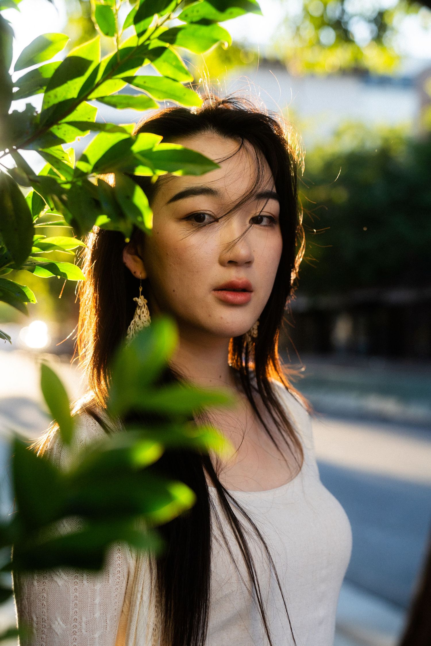 Taipei portrait photography of a woman framed by green leaves in natural light for solo travelers