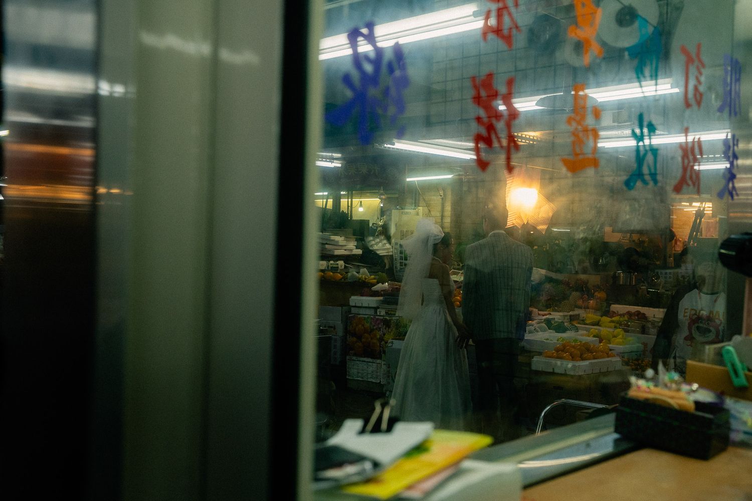Bride and groom framed by warm market lights during their Taipei pre-wedding photography session