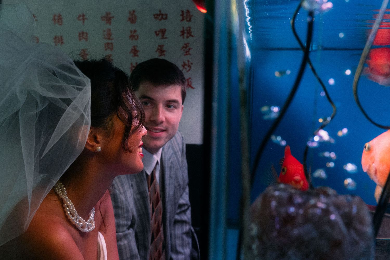 Bride smiling beside a glowing aquarium during a cinematic Taipei engagement photoshoot