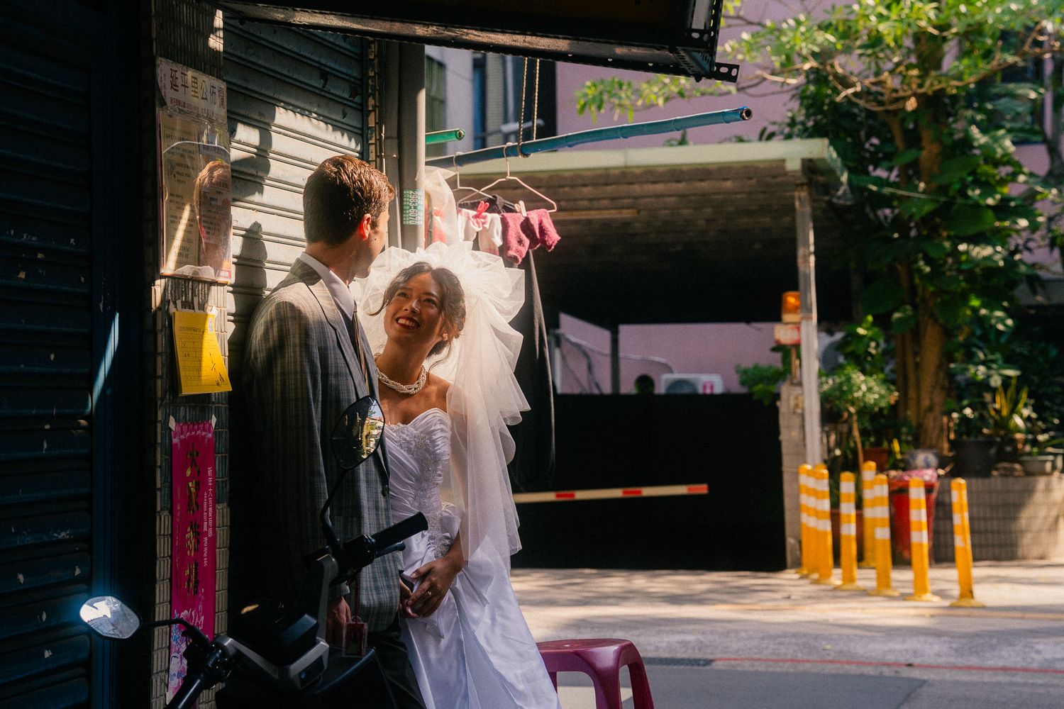 Emily laughing with Nik in warm afternoon light on a quiet street near Dihua Street in Taipei