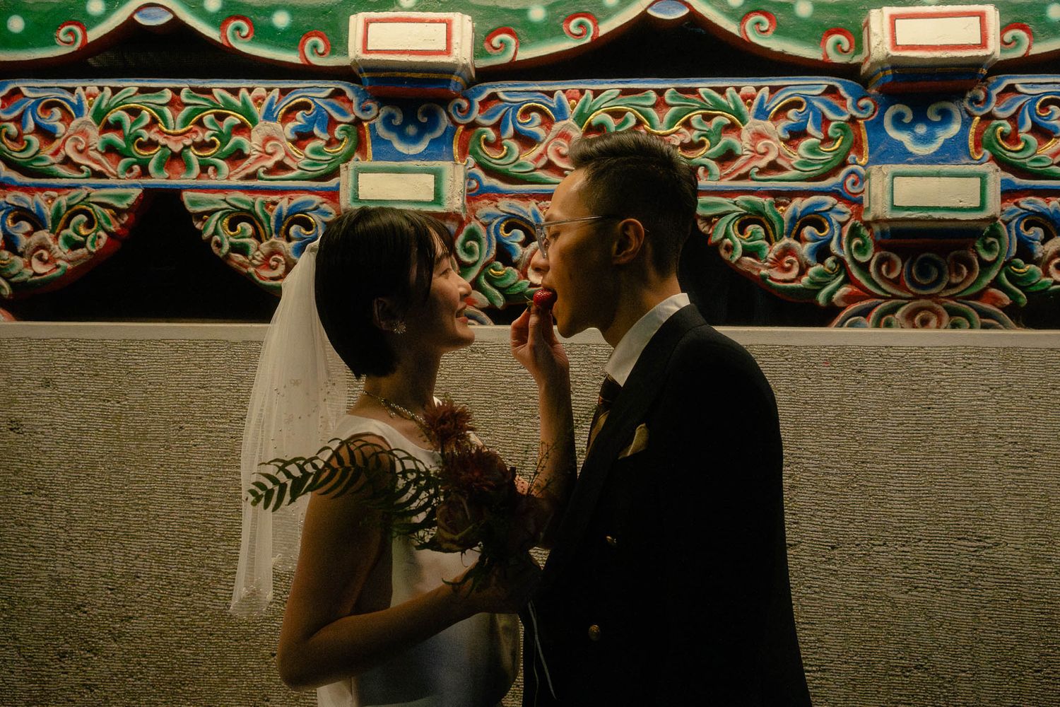 Sunny feeding Leo a strawberry beside Longshan Temple during their intimate Taipei pre-wedding session
