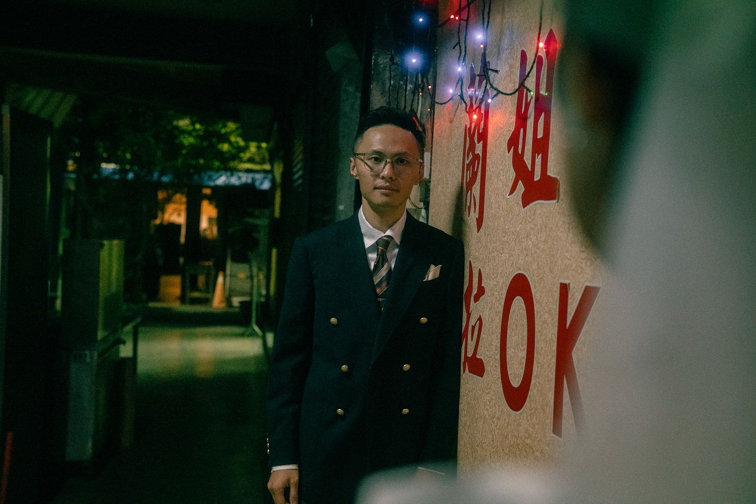 Bride and groom standing beneath a single streetlight in a dark Taipei alley during their pre-wedding photoshoot