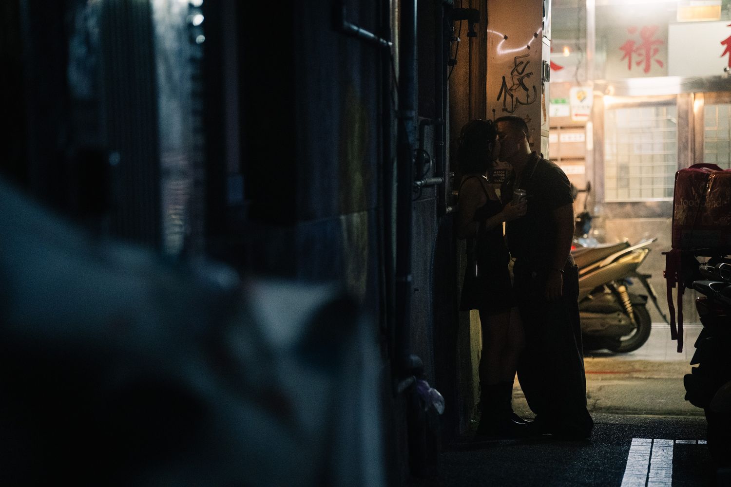 Couple kissing at Ximending side street during a nighttime Taipei photoshoot