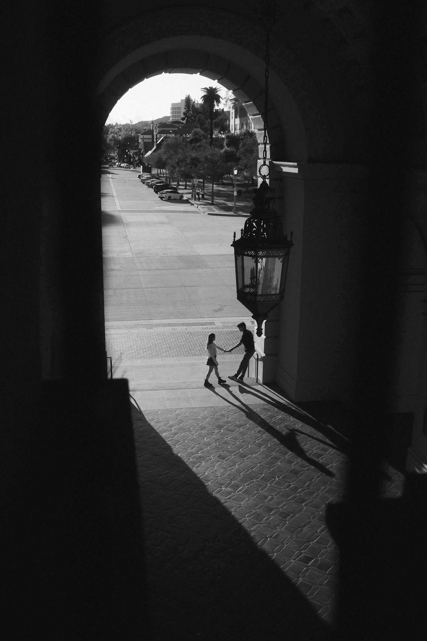 Black and white couple photography with dramatic light and shadow in a city archway