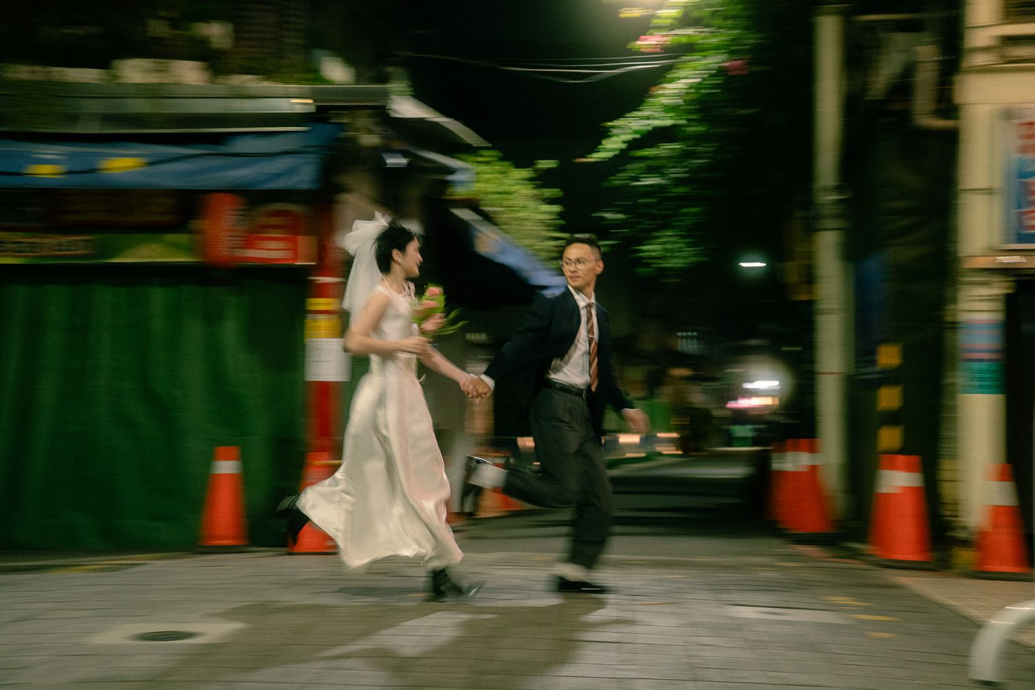 Taipei pre-wedding photographer capturing a bride and groom running hand in hand through a cinematic city street
