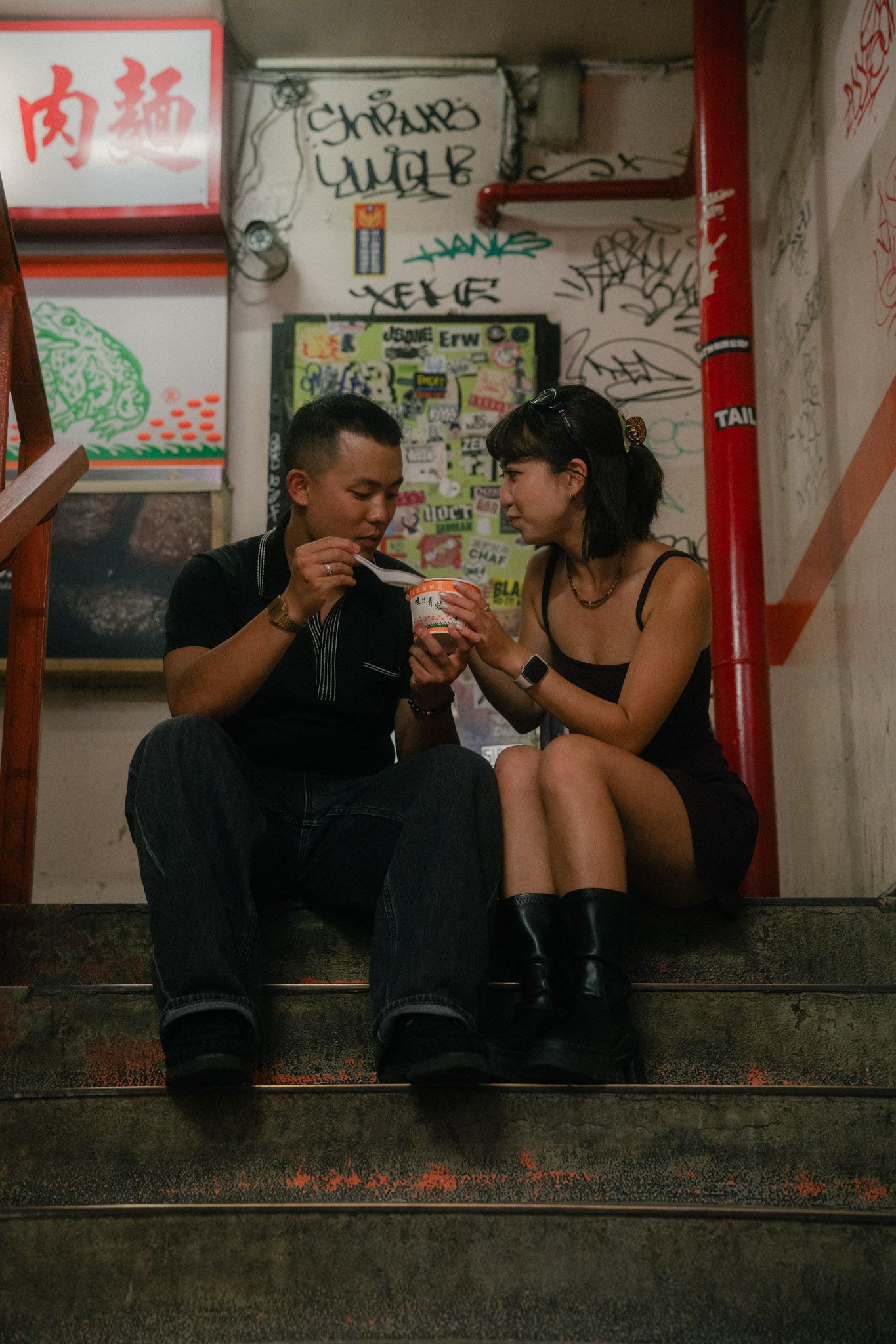Couple eating aiyu jelly together on an old staircase inside Wan Nian Building in Ximending, Taipei