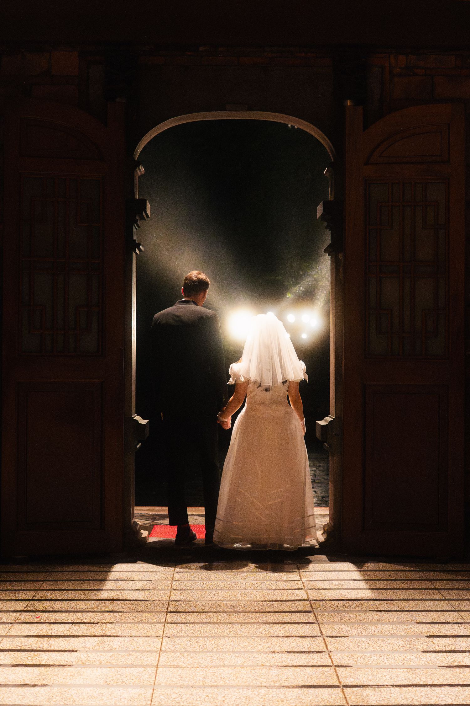 Bride and groom walking through a dramatic temple doorway during their Taipei pre-wedding photoshoot