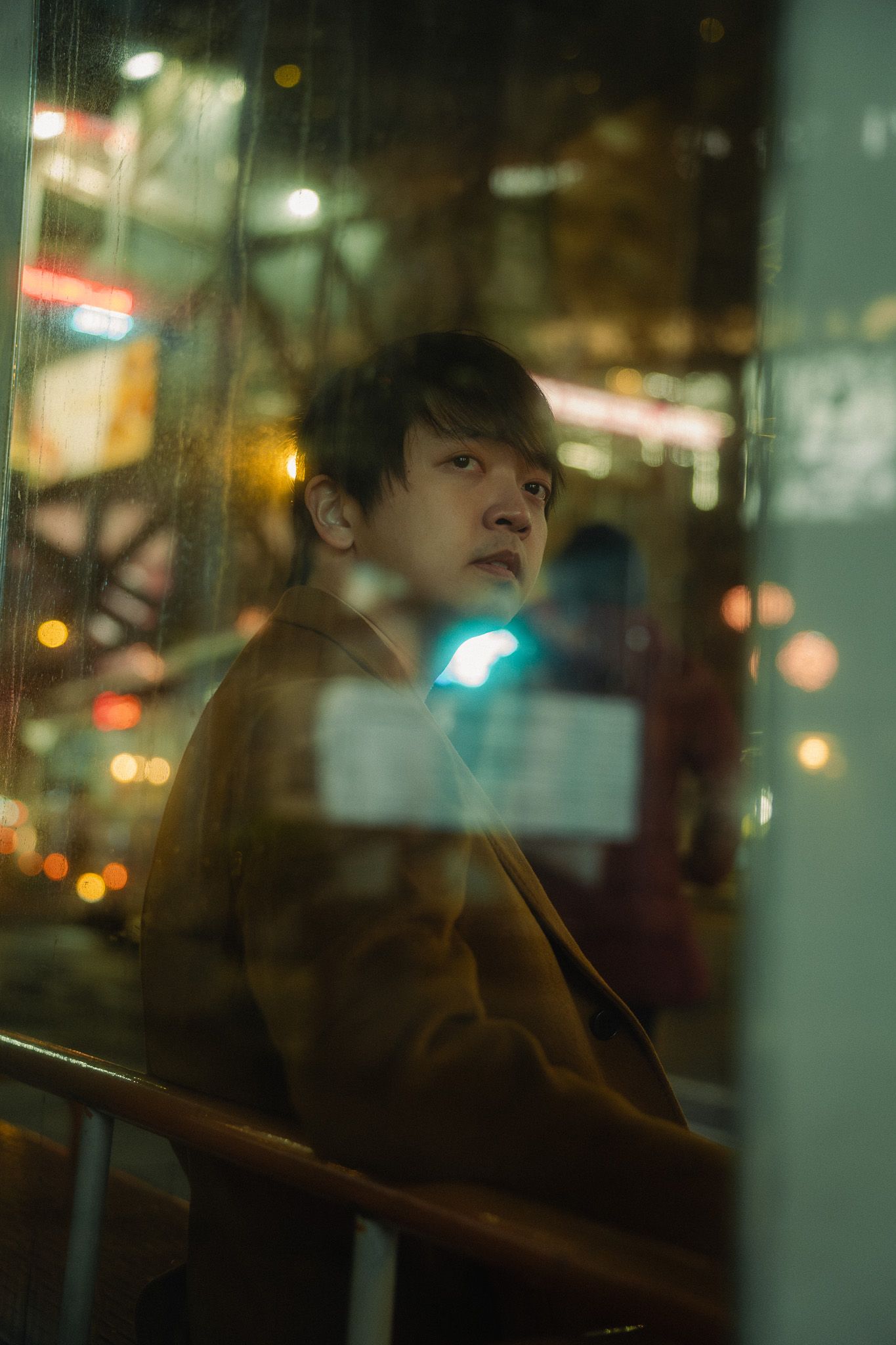Cinematic Taipei lifestyle portrait of a content creator by a window at night
