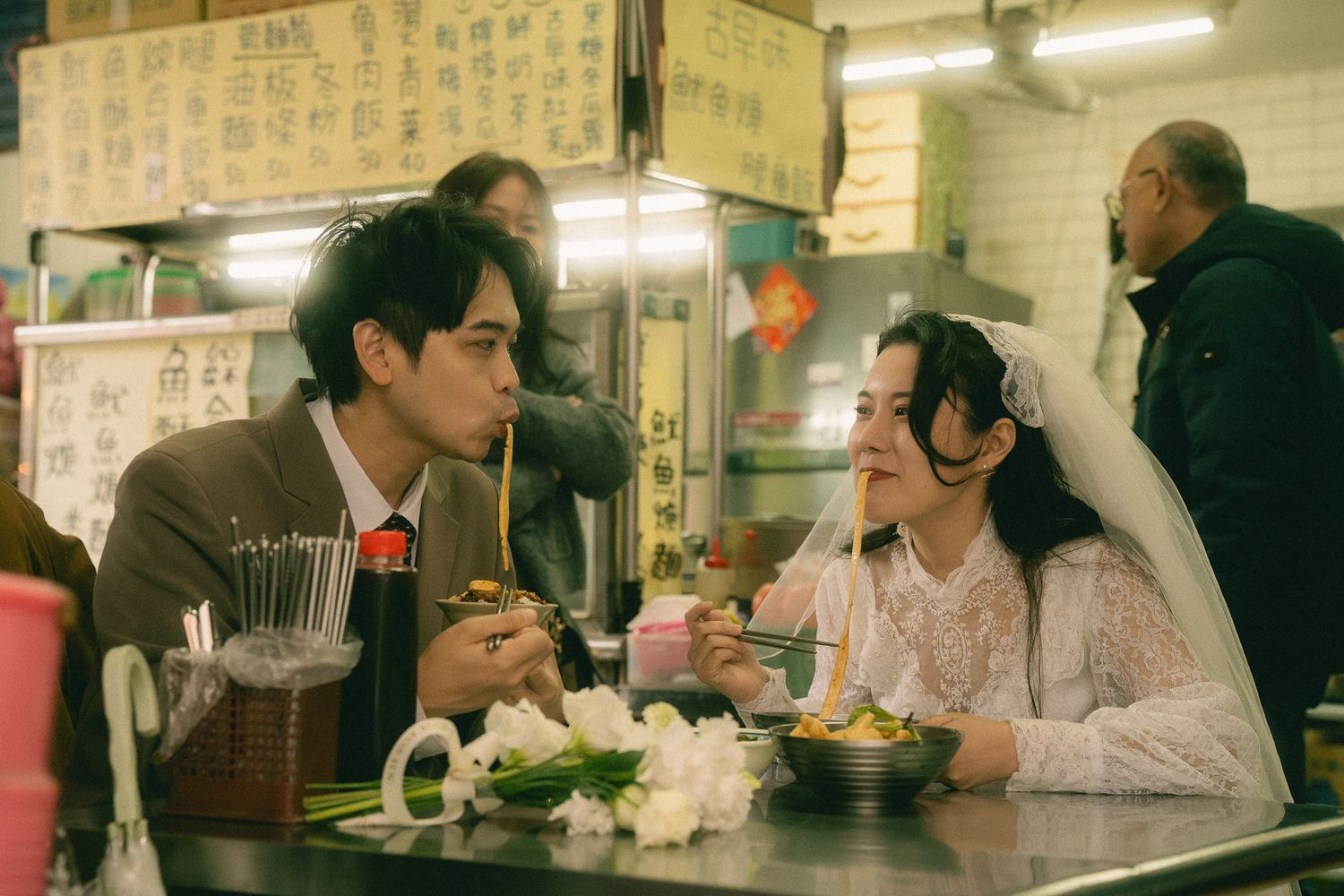 Taipei pre-wedding photography of a couple sharing noodles at a traditional Taiwanese food stall