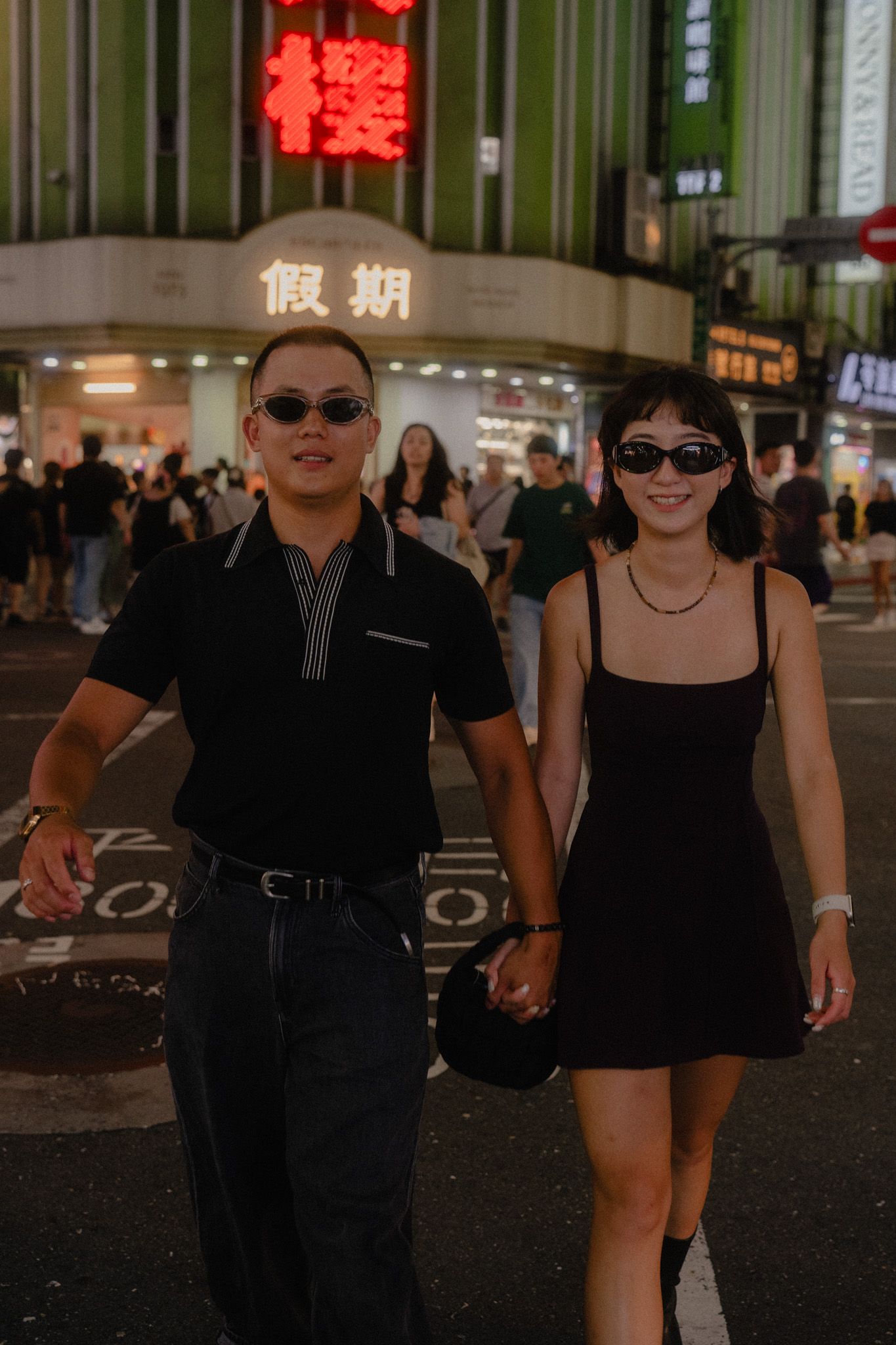 Couple walking through Ximending at night during a candid Taipei pre wedding photoshoot
