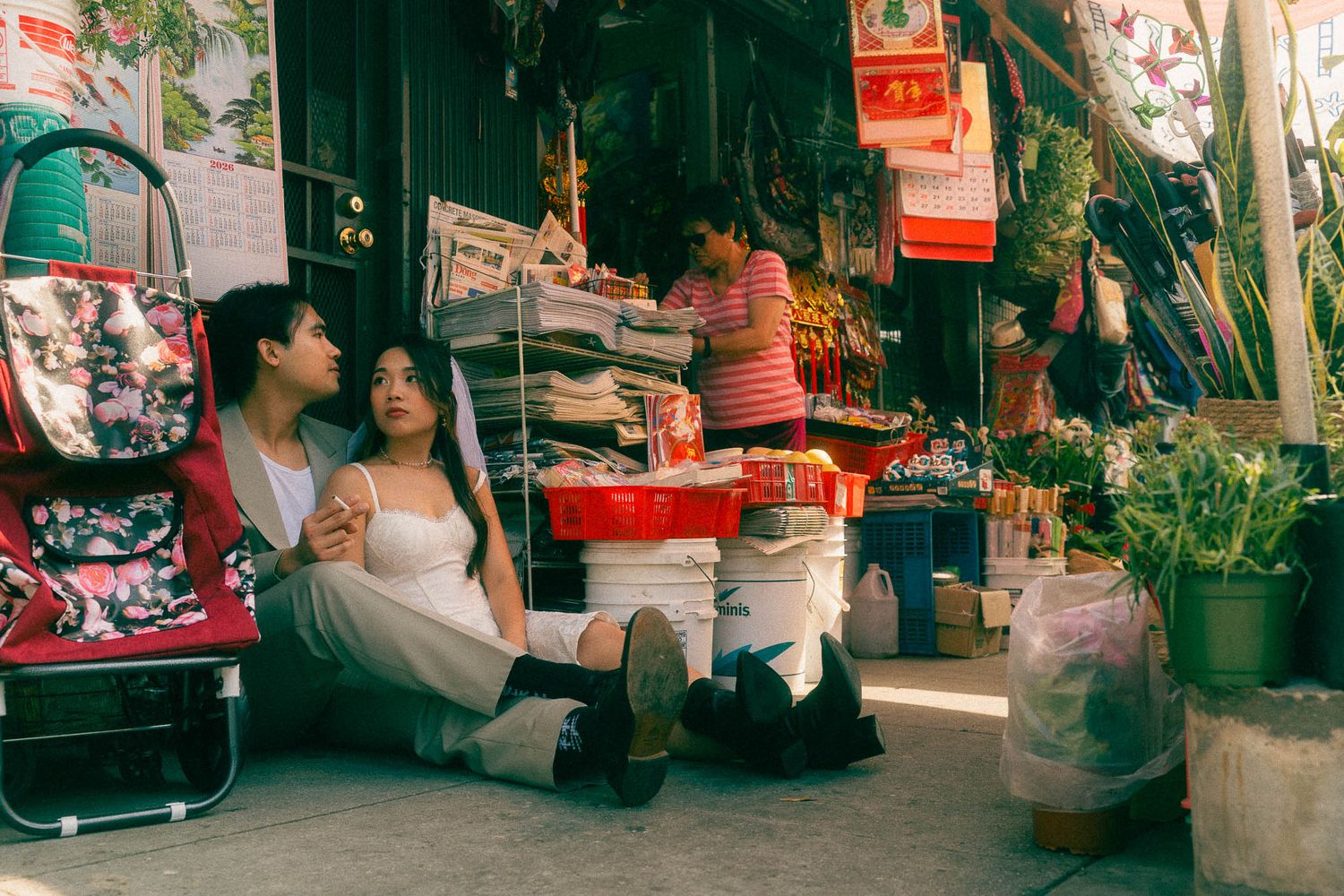 Taipei pre-wedding photo of a couple sitting outside an old Taiwanese street shop with a cinematic storytelling style