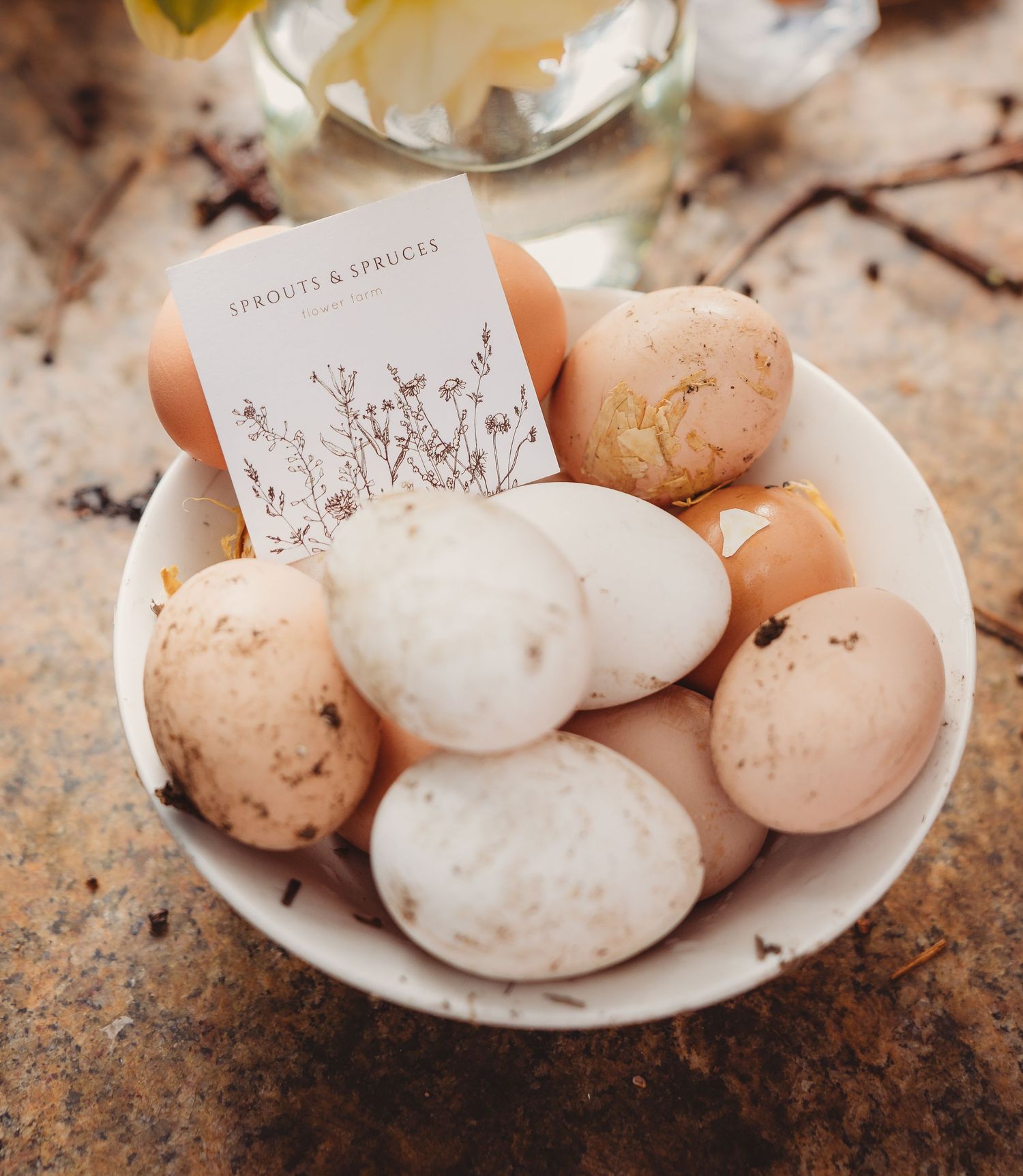 Bowl of natural speckled eggs with a Sprouts and Spruces business card on top.