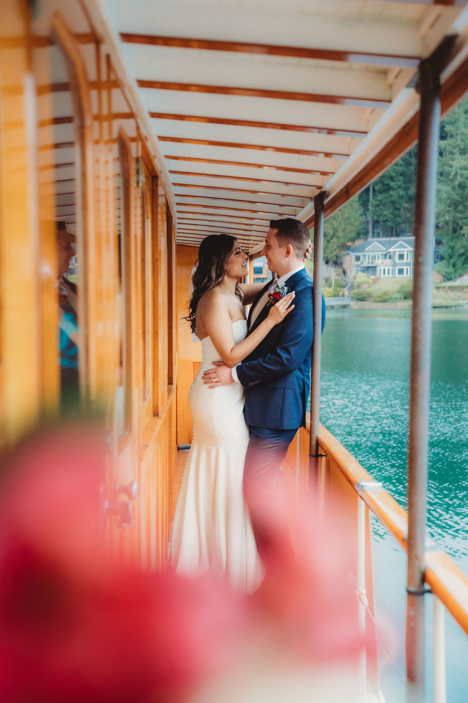 Bride and groom share intimate moment on wooden boat deck overlooking turquoise water in romantic wedding portrait. South Carolina