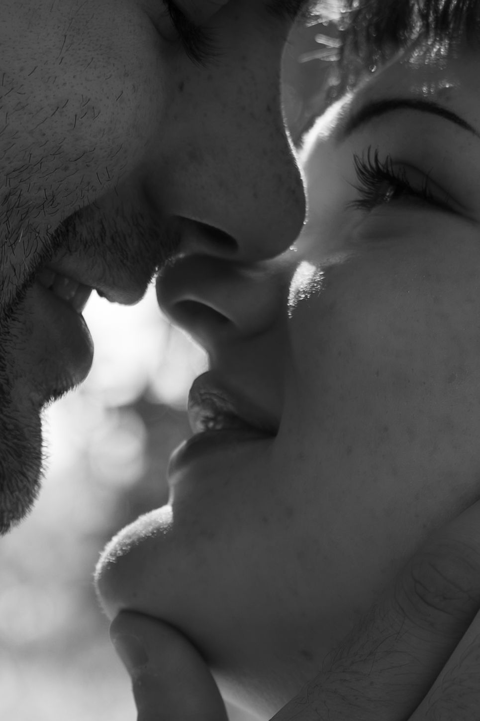 Black and white close-up of a romantic couple about to kiss, capturing an intimate and tender moment.