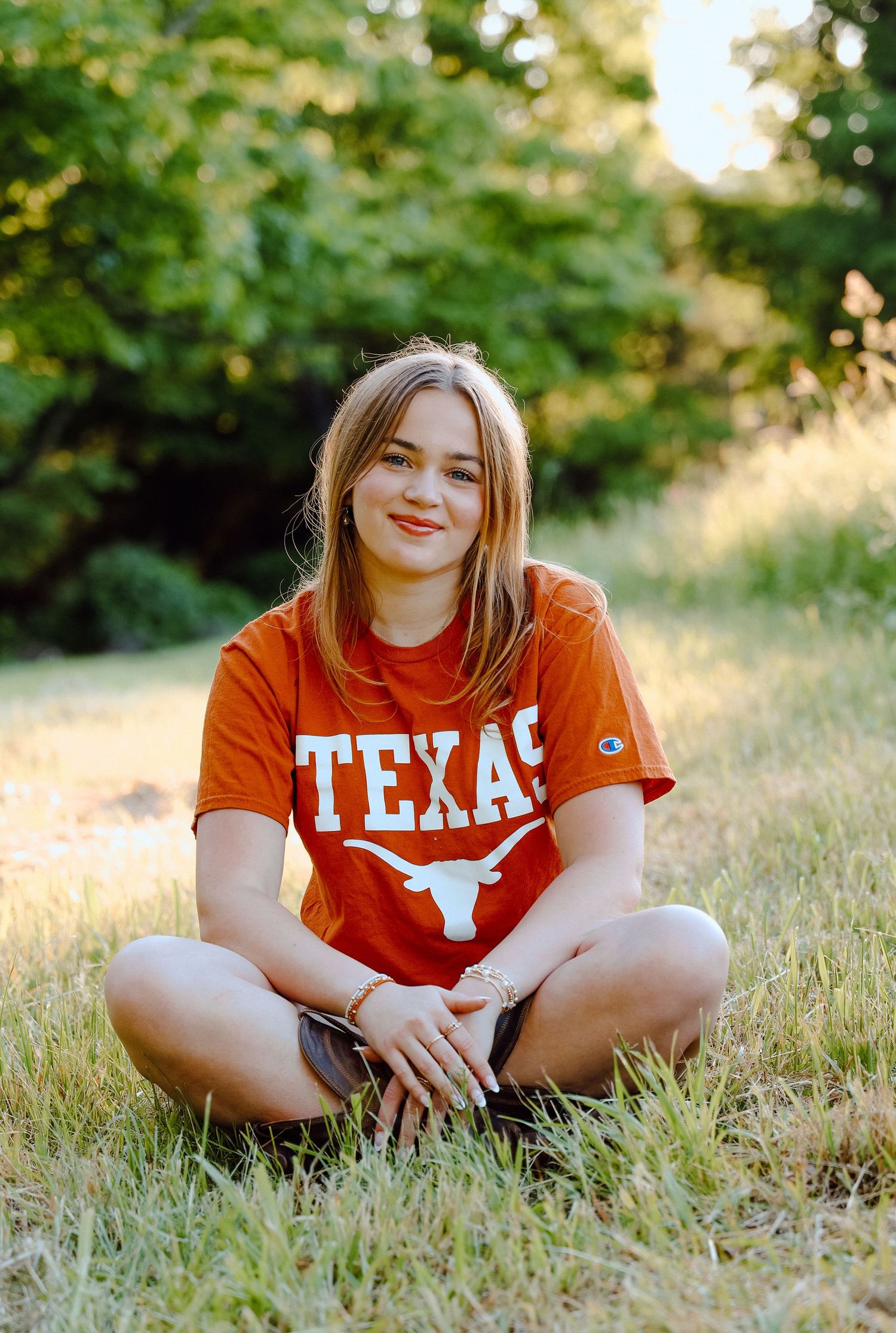 Senior portrait of a future University of Texas student, sitting in warm natural light with proud Texas spirit and relaxed outdoor vibes.