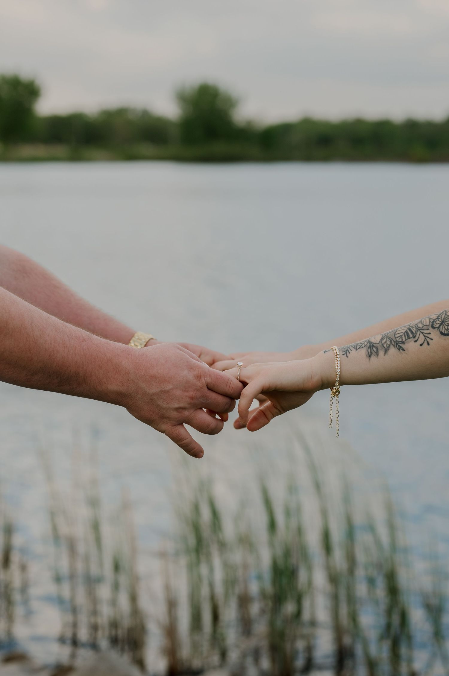 Engagement couple holding hands while walking through a park during sunset photos in Des Moines Iowa