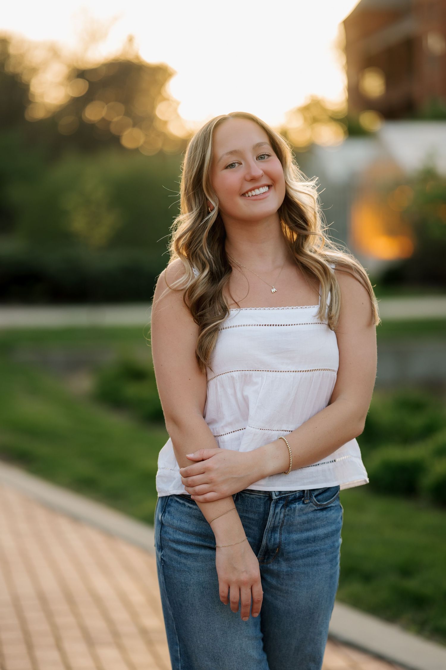Senior girl laughing while standing in a field during Iowa golden hour photography session