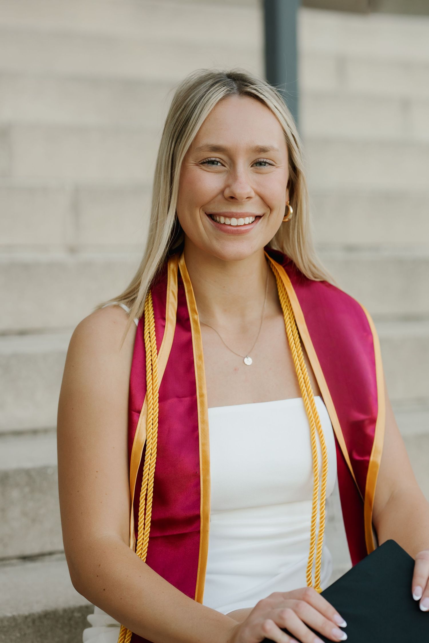 Iowa State senior leaning against brick campus building during natural light graduation portraits