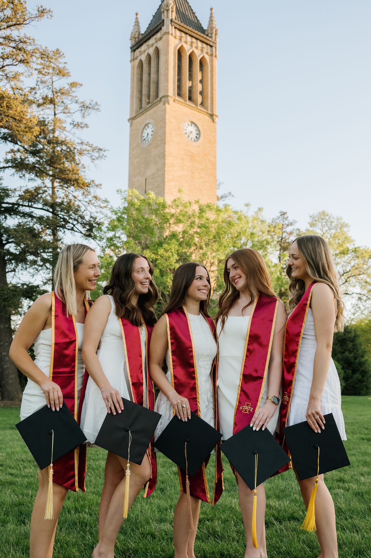 Candid laughter shot of Iowa State grad with friends during campus graduation photos in Ames Iowa
