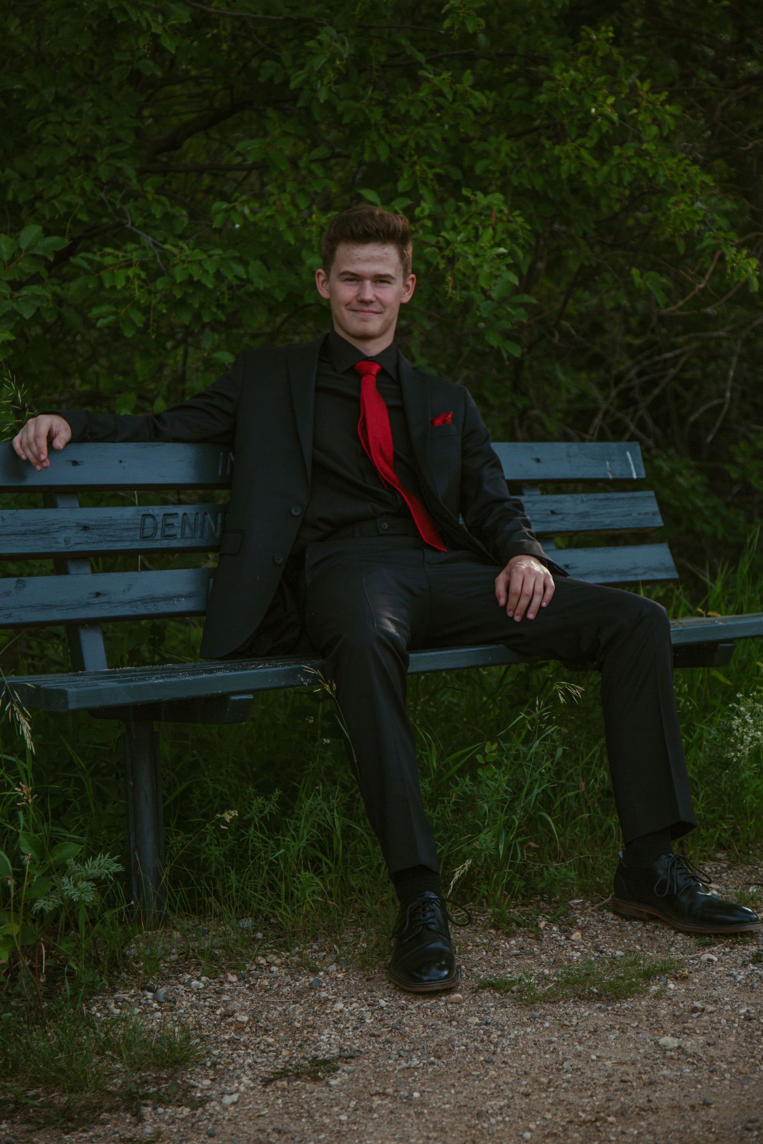 Casual portrait series on wooden park bench surrounded by greenery.