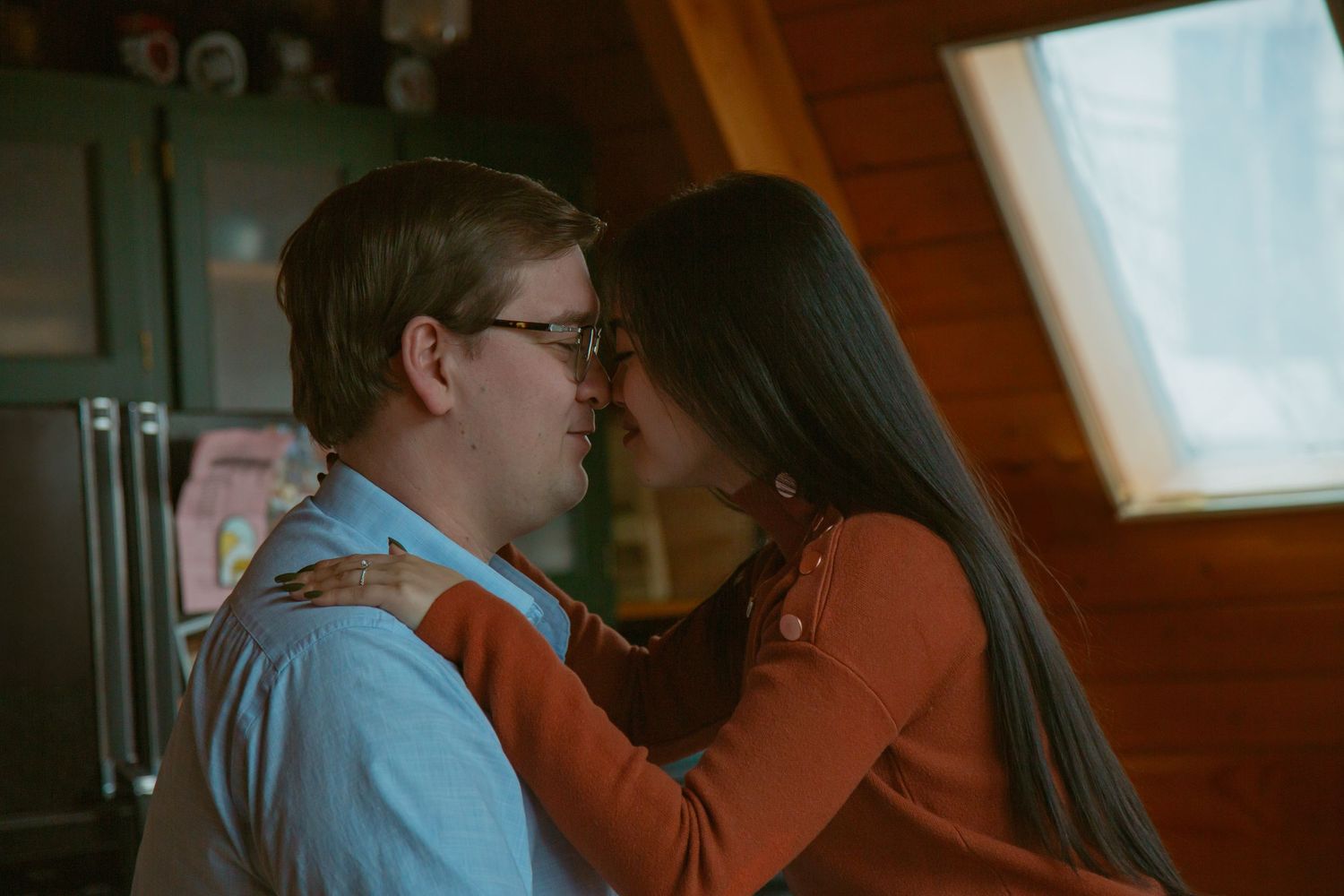 Intimate indoor moment between couple in cozy kitchen setting.