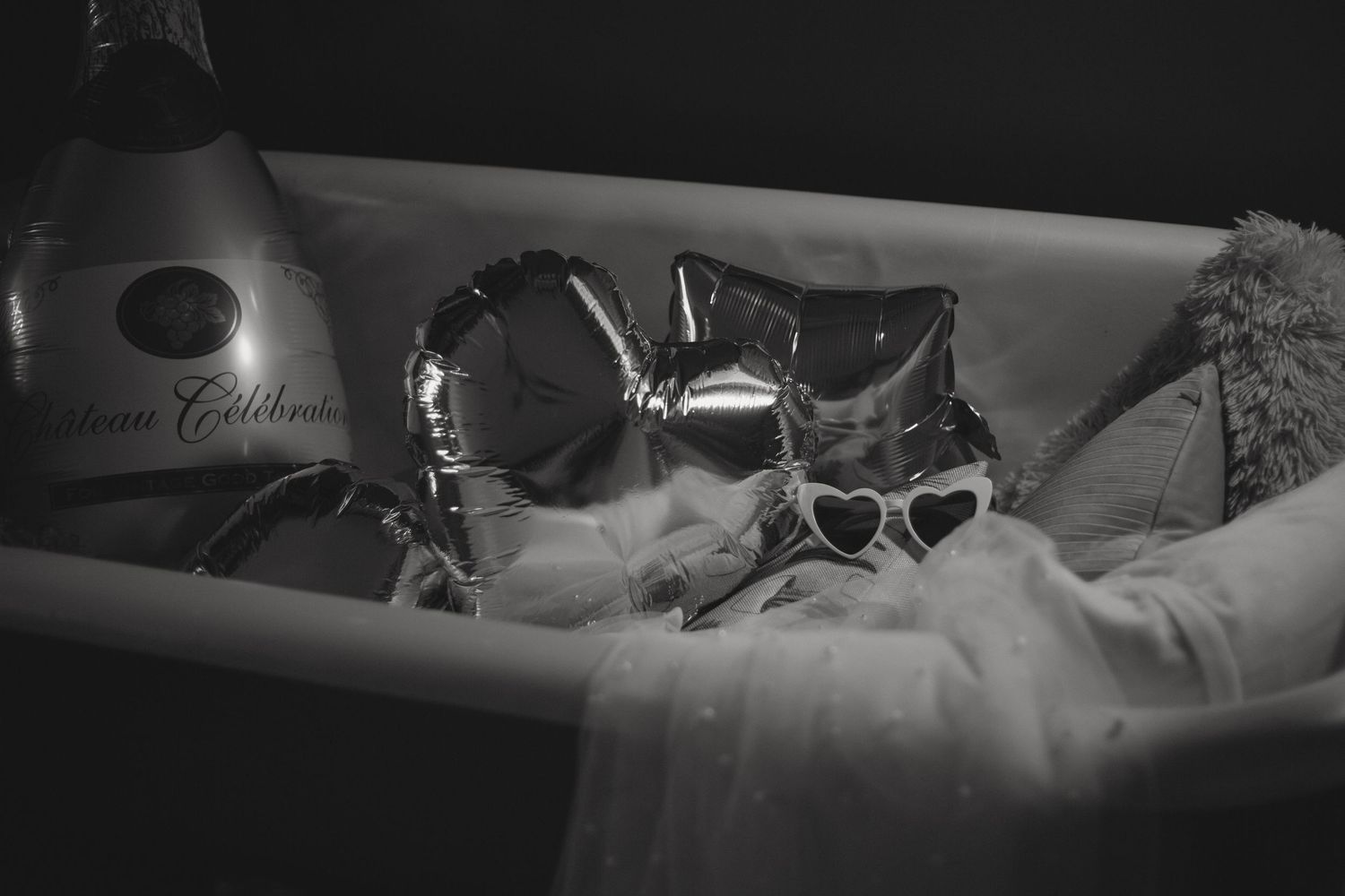 Black and white artistic photo of someone reclining in dim lighting.