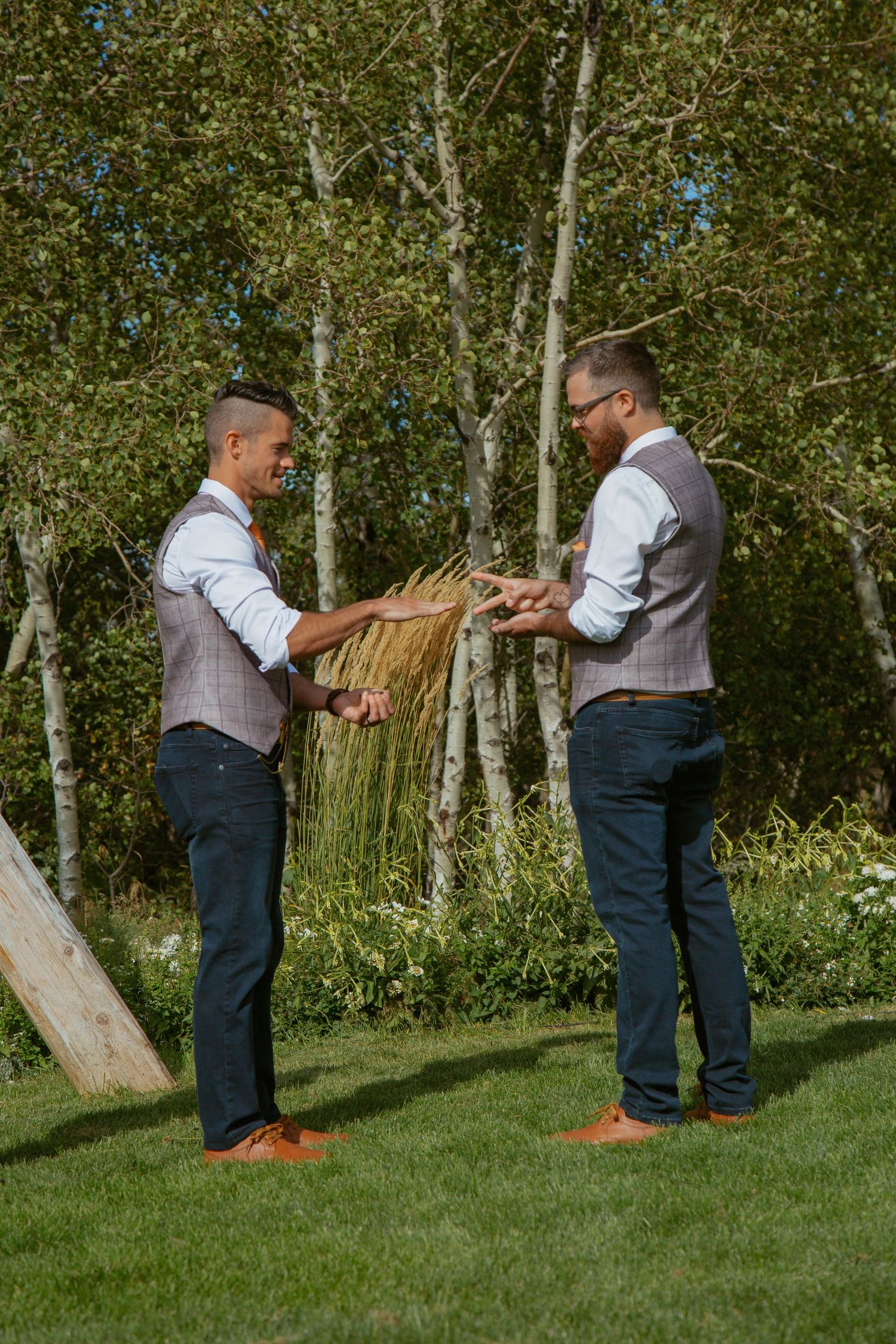 Two people share a special moment near wooden beams in a sunlit outdoor setting.
