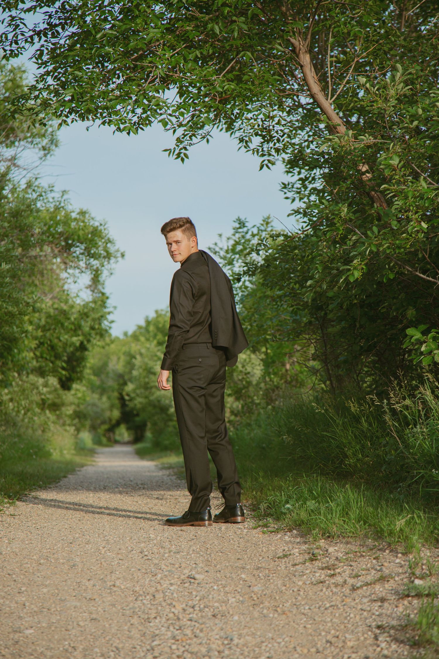 Series of formal poses on gravel path surrounded by green foliage.