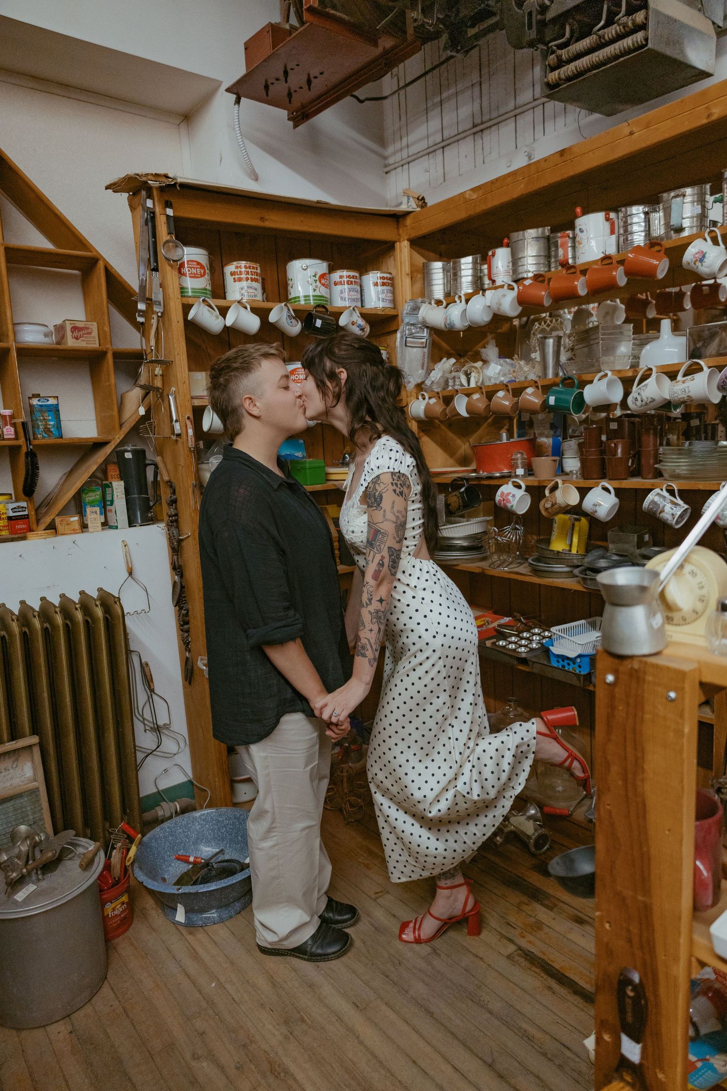 Couple sitting in a rustic room with hanging lights and wooden beams.
