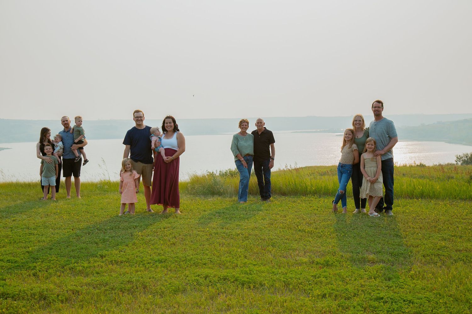 People scattered across grassy hilltop landscape during golden hour.