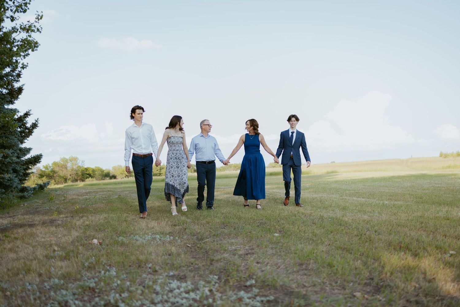 Group poses together on hilltop with scenic landscape view in background.