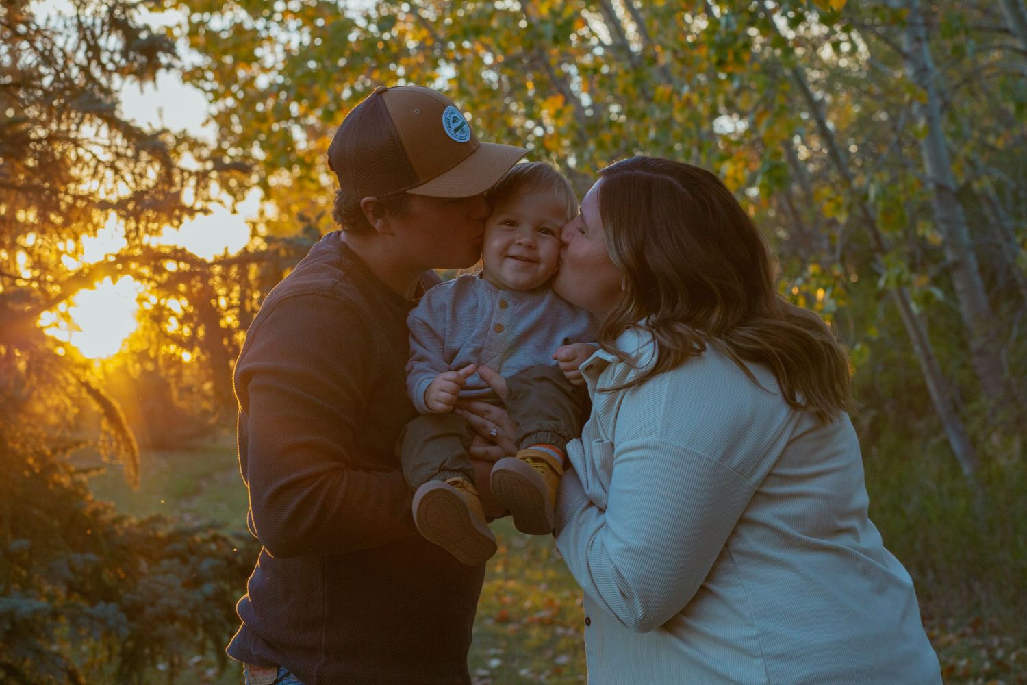 Intimate family moment captured during golden hour in a natural outdoor setting.