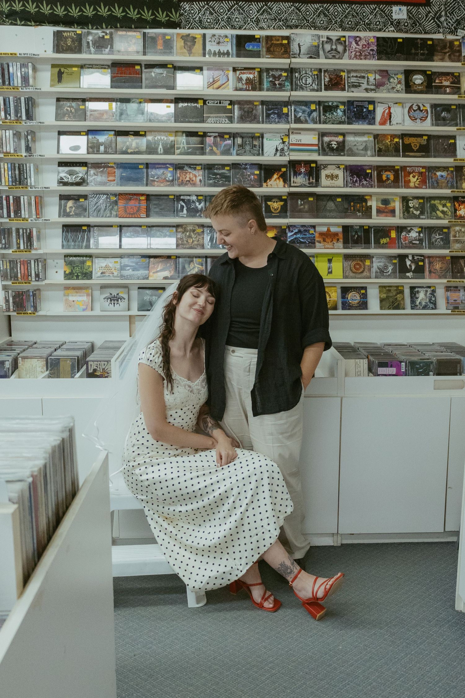 Couple in vintage style clothing browsing through a record store collection.