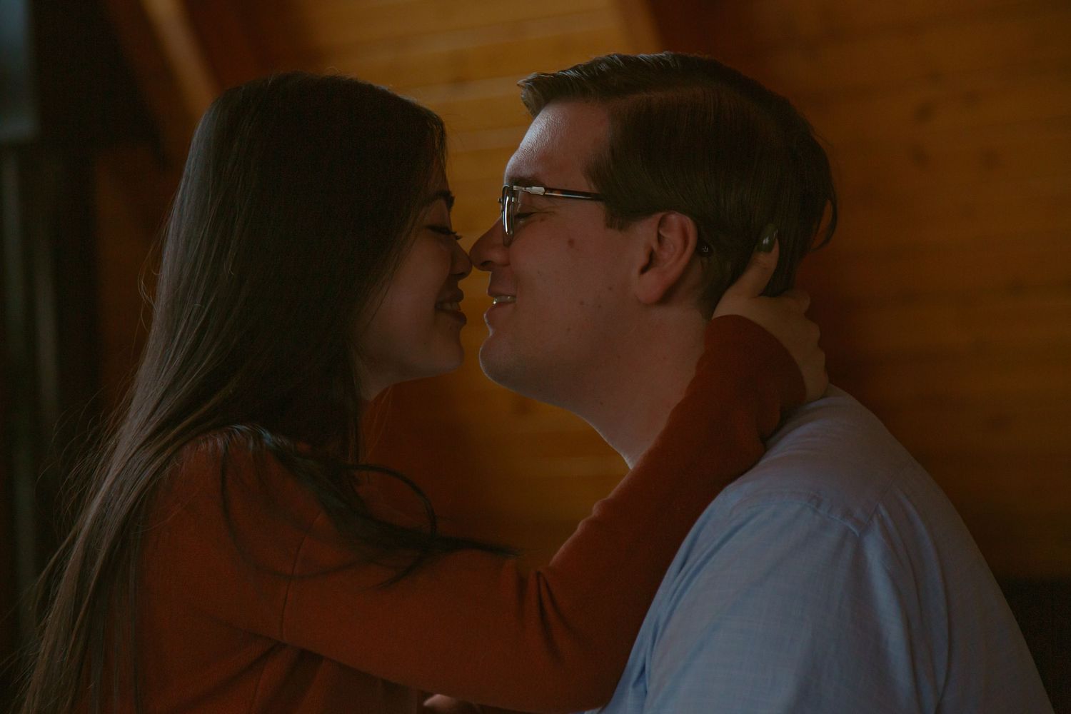Two individuals review papers together in a dimly lit wooden interior.