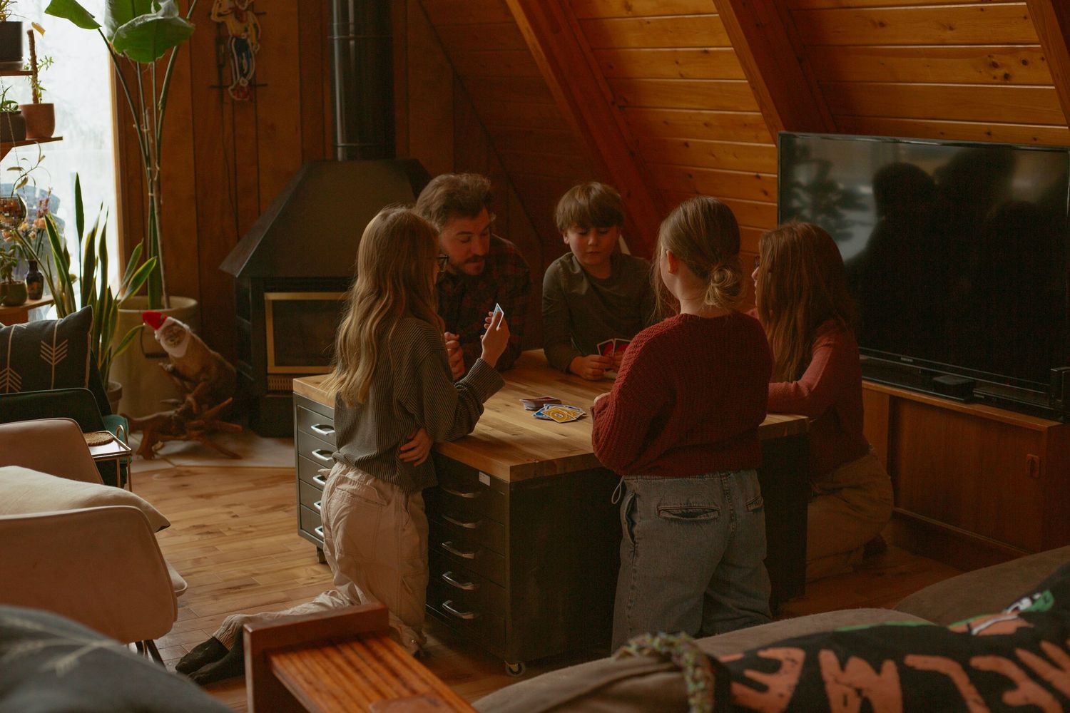 People sitting around a table playing games in a rustic room with wood paneling.
